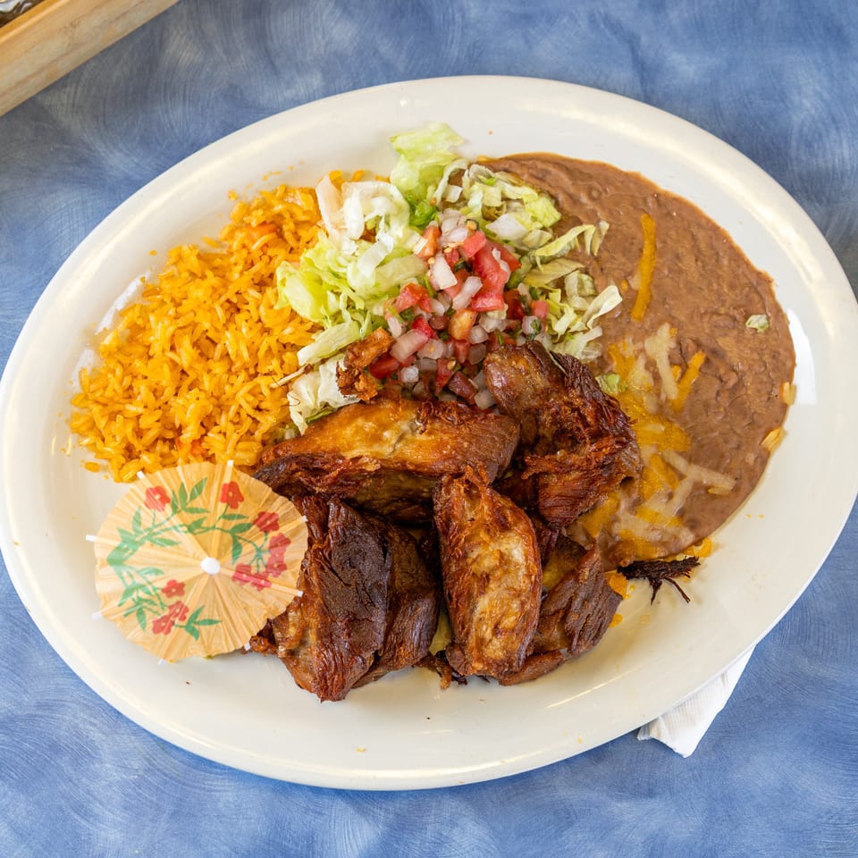 Mexican platter with orange rice, refried beans, shredded lettuce, pico de gallo, and crispy fried chicken.